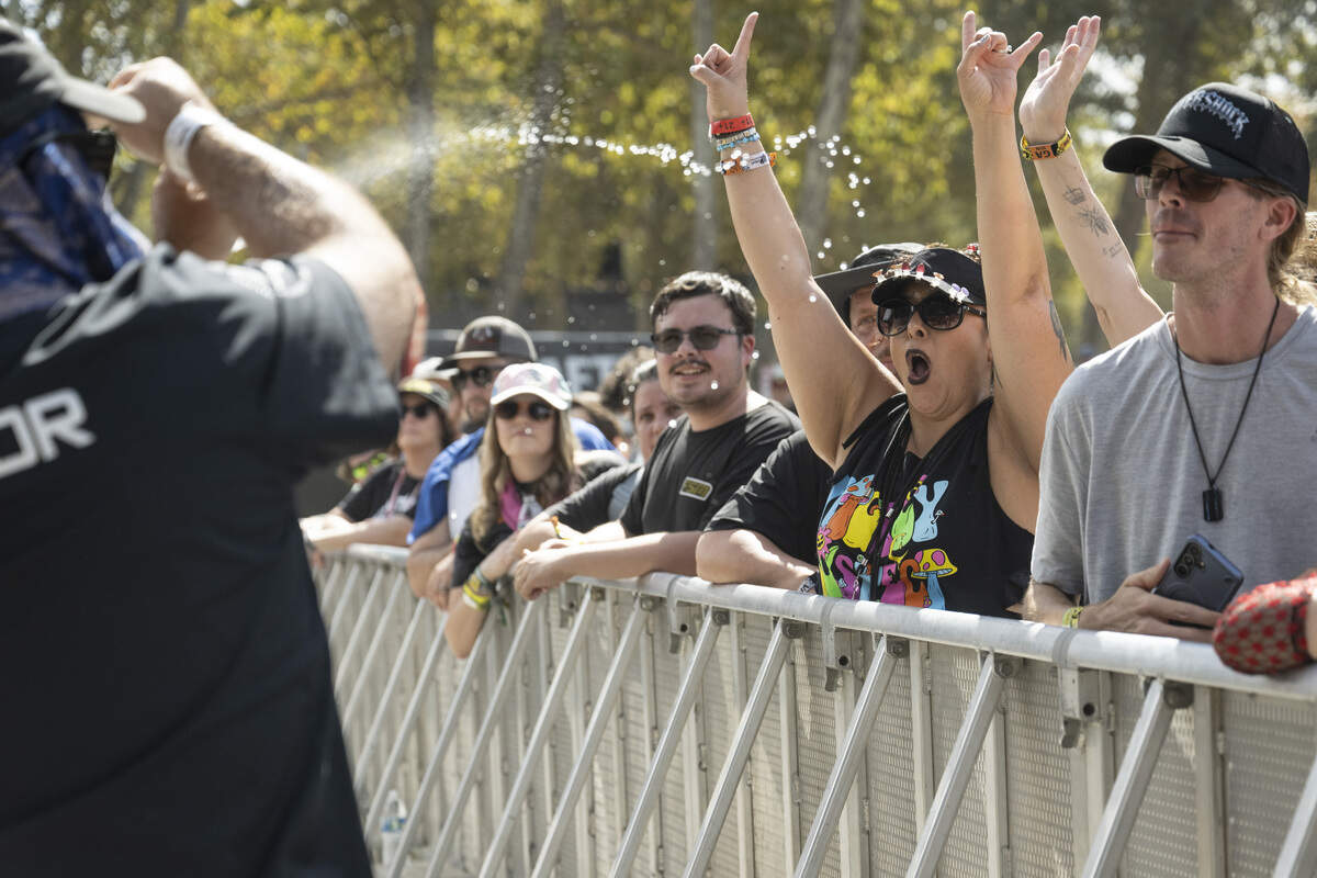 A security guard sprays fans with water as Oleander performs at Aftershock at Discovery Park in Sacramento on Sunday.